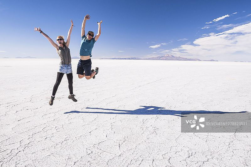 年轻游客情侣在玻利维亚乌尤尼盐沼旅行图片素材