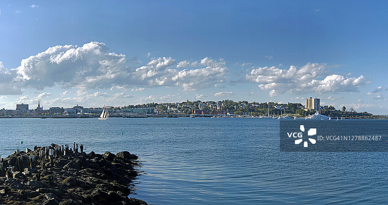 一艘帆船驶出波特兰港，背景是美国缅因州波特兰市图片素材