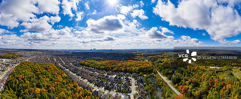 加拿大安大略省旺市伍德布里奇的Pine Village Dr和Vellore Village社区两侧的多种颜色树叶图片素材