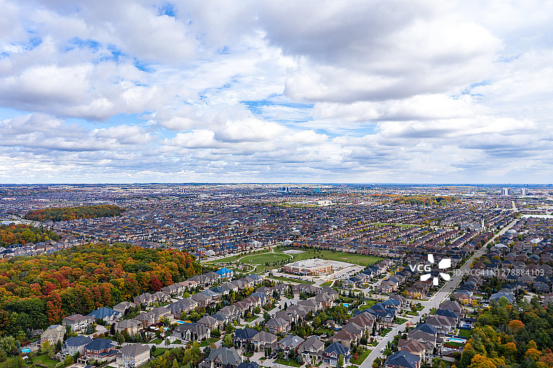 加拿大安大略省旺市伍德布里奇的Pine Village Dr和Vellore Village社区两侧的多种颜色树叶图片素材