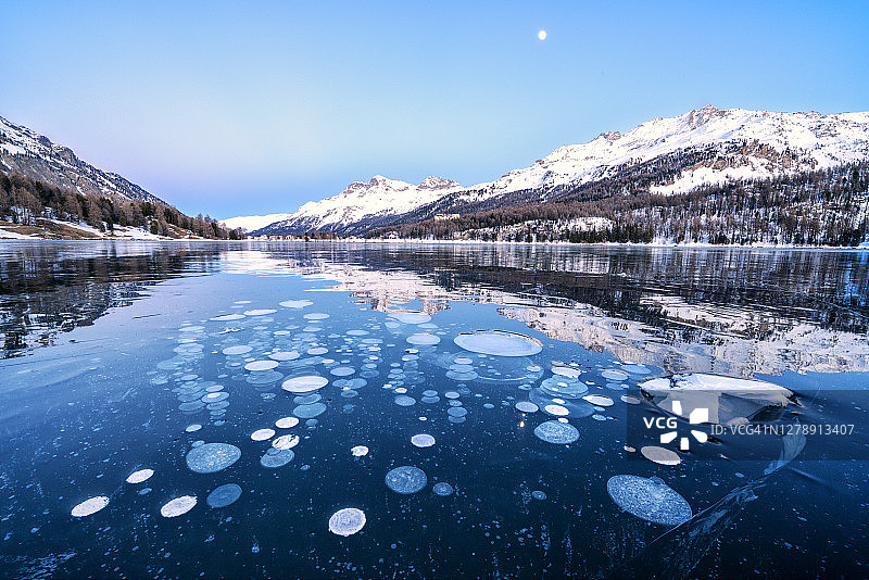 瑞士夕阳下锡尔斯湖中捕获的冰泡图片素材