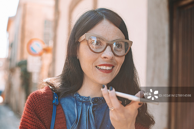 在城市中使用手机发短信的意大利女人图片素材