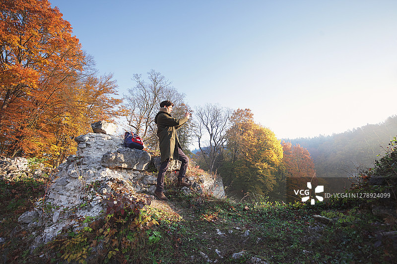 秋季清晨男子在山区拍照图片素材