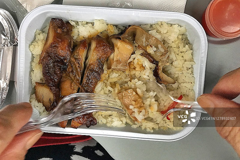 在飞机上吃经济舱午餐的男人俯视图图片素材