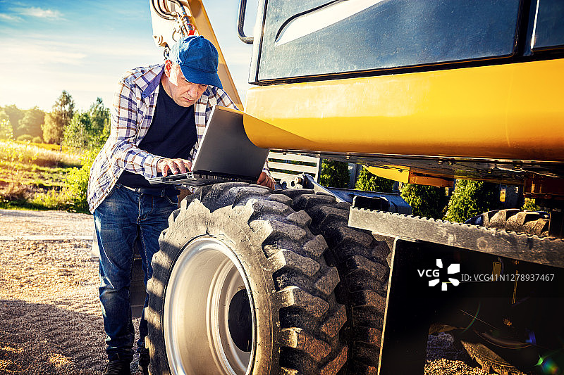 挖掘机操作员在笔记本电脑上查看数据图片素材