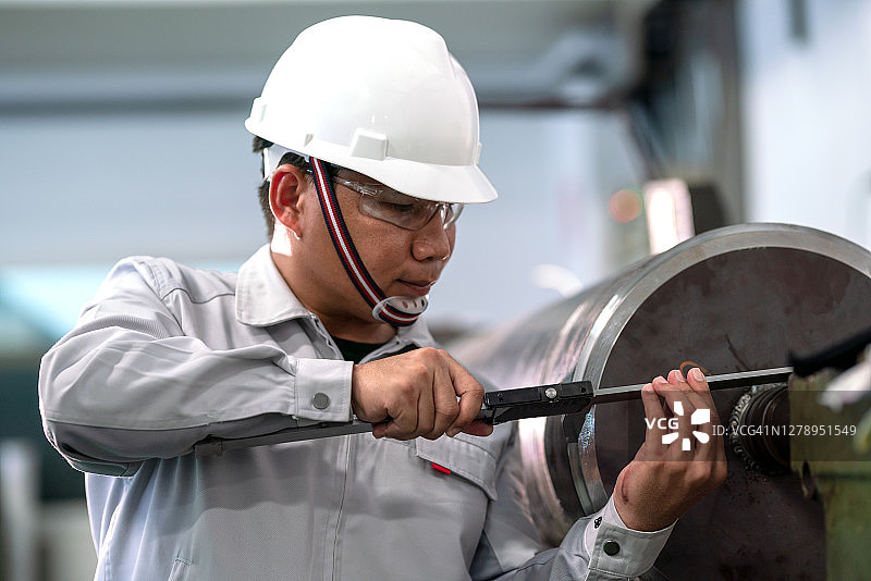 工人在机器工厂使用游标卡尺测量图片素材