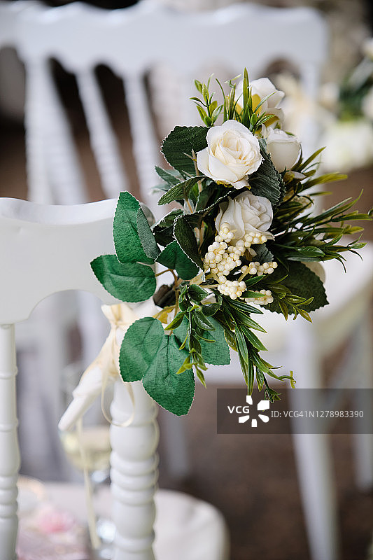 用鲜花和亮缎带装饰的白色木椅，婚礼装饰图片素材