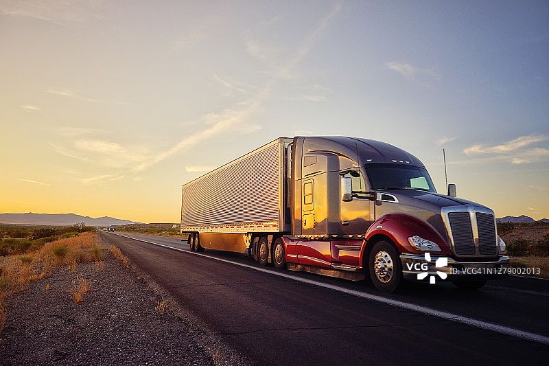 行驶在美国西部乡村州际公路上的长途半挂卡车图片素材
