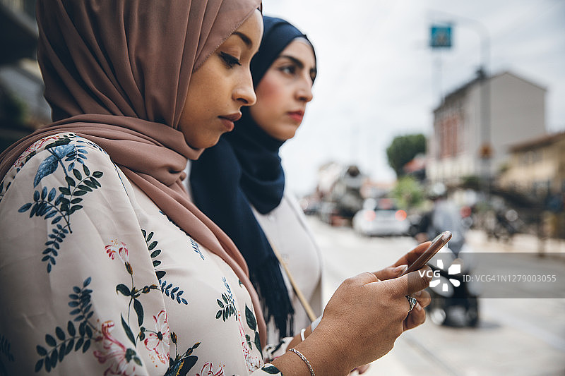 在公交车站等候拼车的穆斯林妇女图片素材