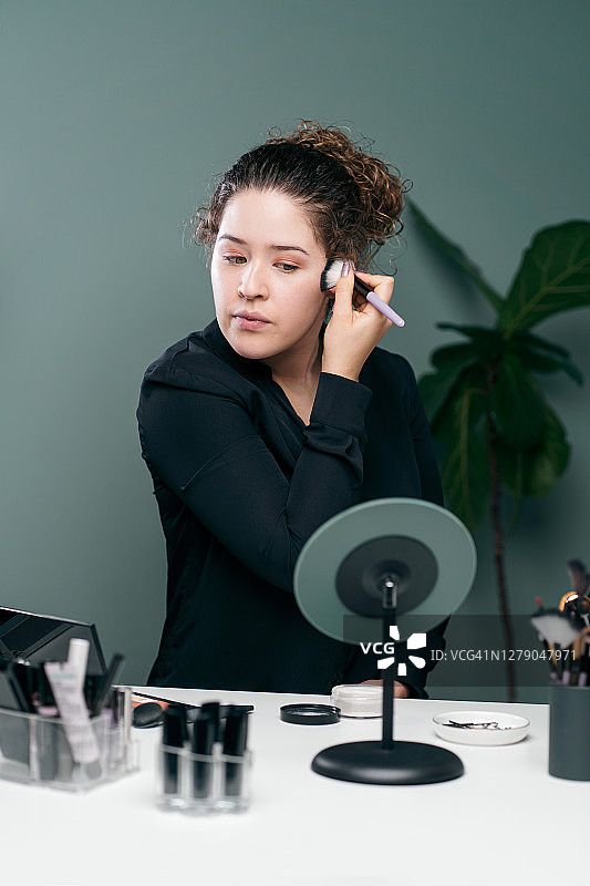 年轻拉丁裔女人使用化妆刷图片素材