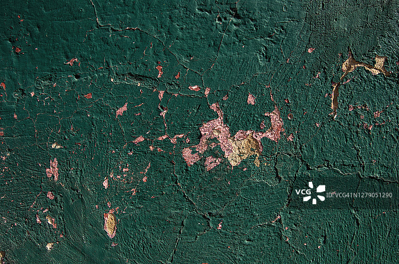 灰泥墙上剥落的深绿色油漆图片素材