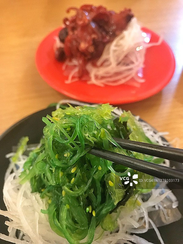 男子享用日式料理：海藻芝麻沙拉俯视图图片素材