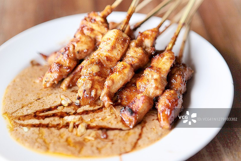 沙爹配花生酱在白色盘子里的俯视图图片素材