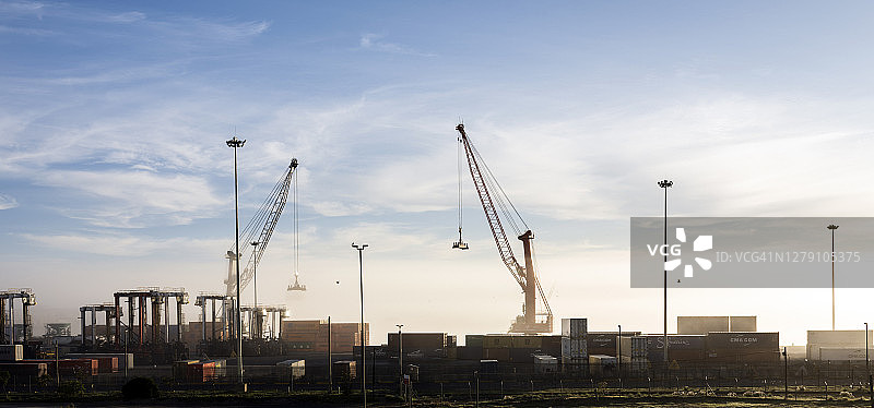 新冠疫情旅行禁令期间，商业码头上的起重机和集装箱图片素材
