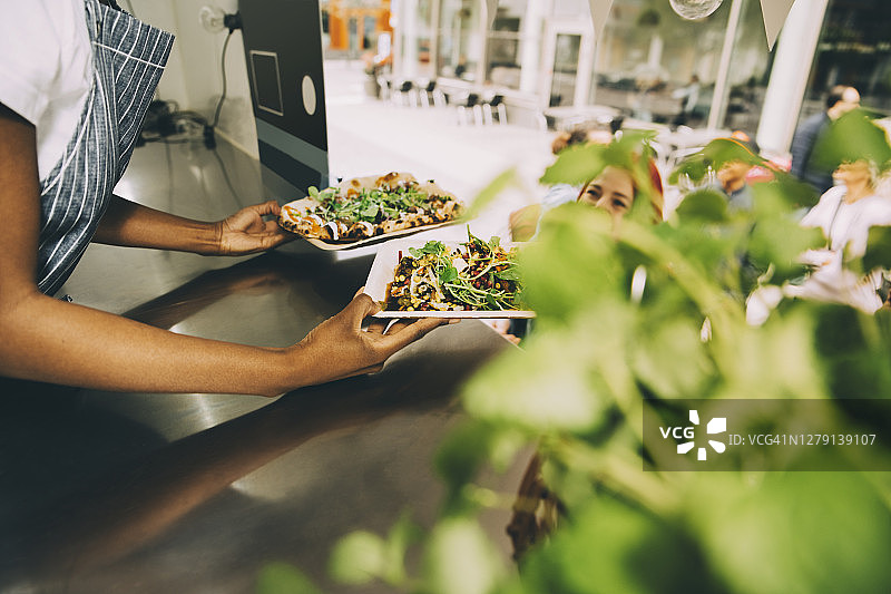 女店主在城市里给顾客提供街头食物的身体中部照片图片素材