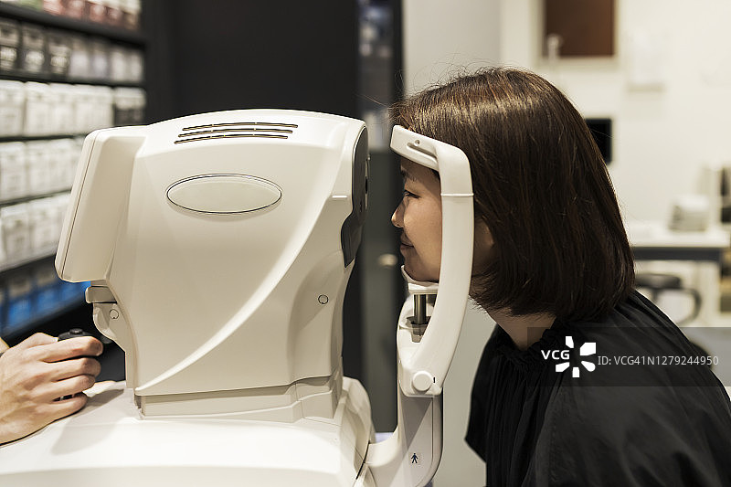 女士使用屈光仪进行眼科检查图片素材