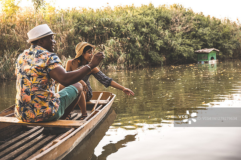 情侣在划艇上喂鱼图片素材