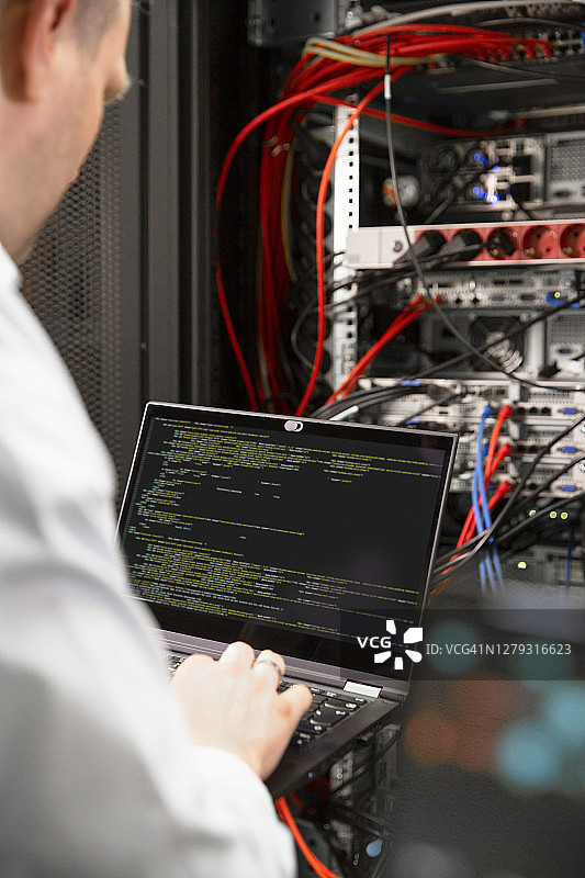 数据中心男性IT专业人士使用笔记本电脑特写图片素材