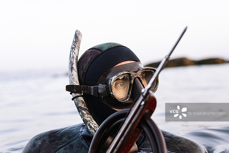戴着鱼叉的潜水镜在海中游泳的中年男人特写图片素材