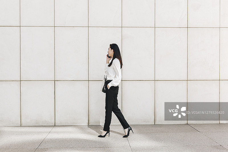 商务人士在城市中使用智能手机通话图片素材