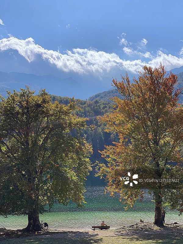 女子在湖边享受美丽的暖秋图片素材