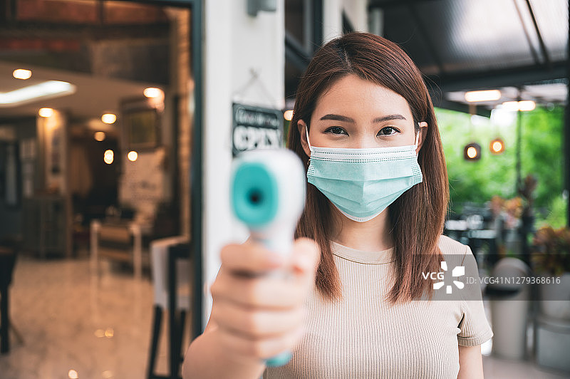 亚洲女服务员正在检查顾客的体温图片素材