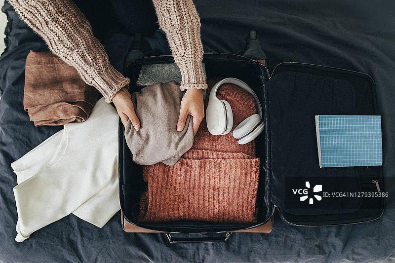 女子收拾行李箱准备冬季旅行图片素材