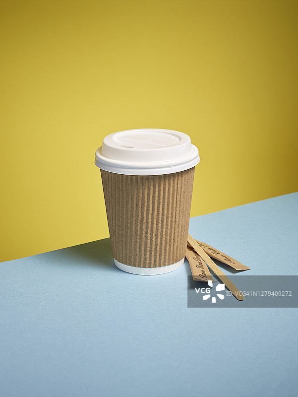 蓝色背景下的纸咖啡杯图片素材