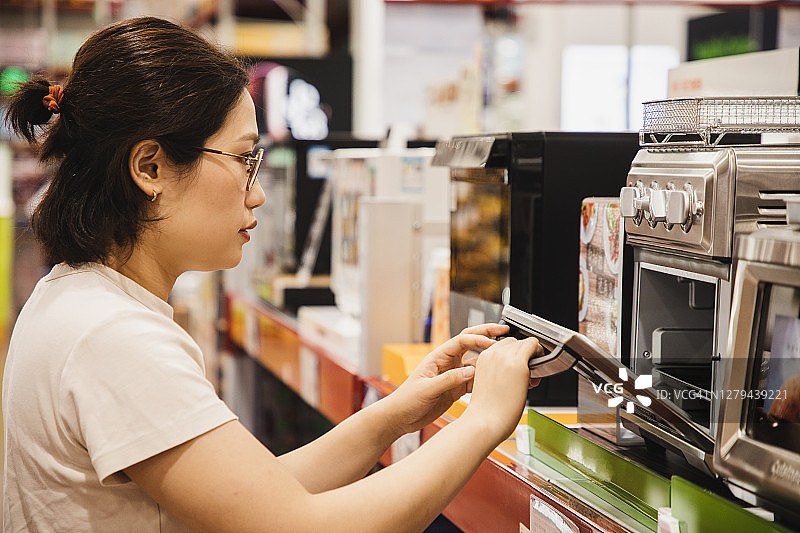 正在选购烤箱的亚洲女性图片素材