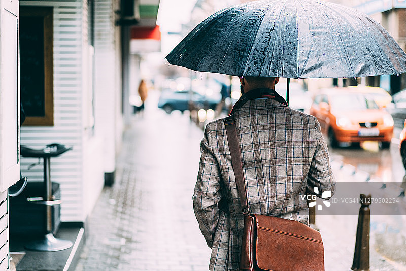 雨天室外撑伞的商人图片素材