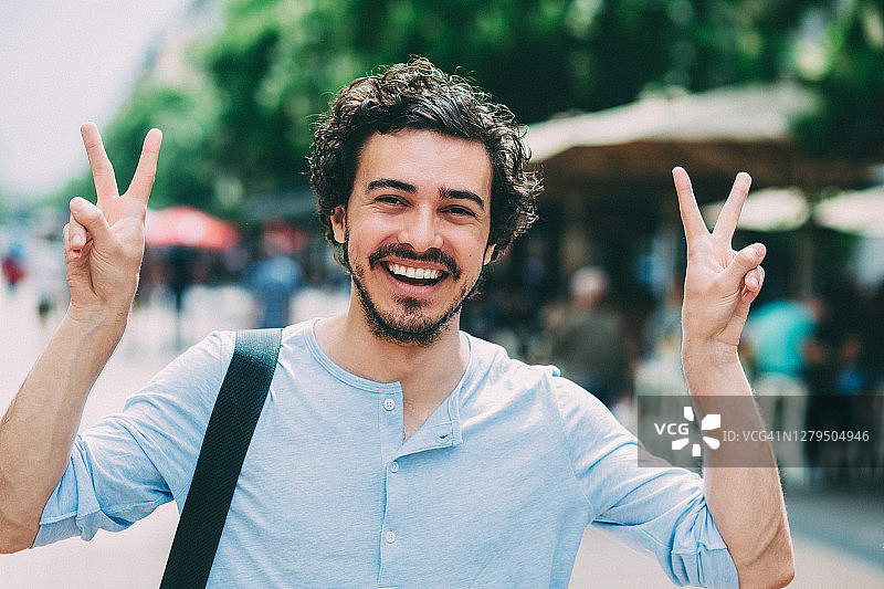 幸福的男人用双手做出V字手势图片素材