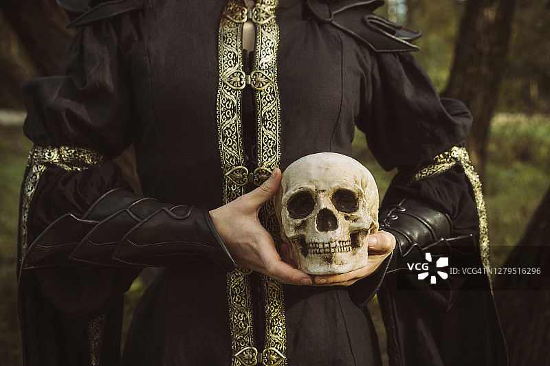 一位身穿黑色连衣裙的女人手持魔法灯笼图片素材