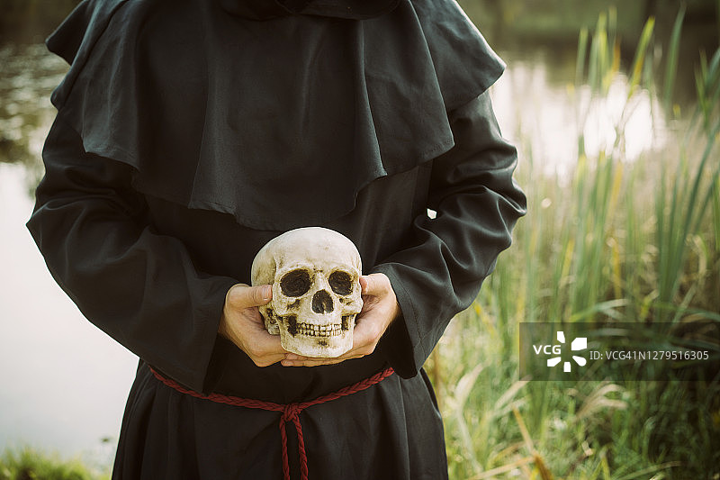 身穿黑色法衣的僧侣手持魔灯图片素材