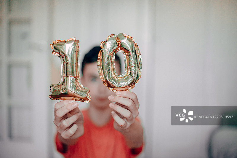男孩手持金色10号气球图片素材