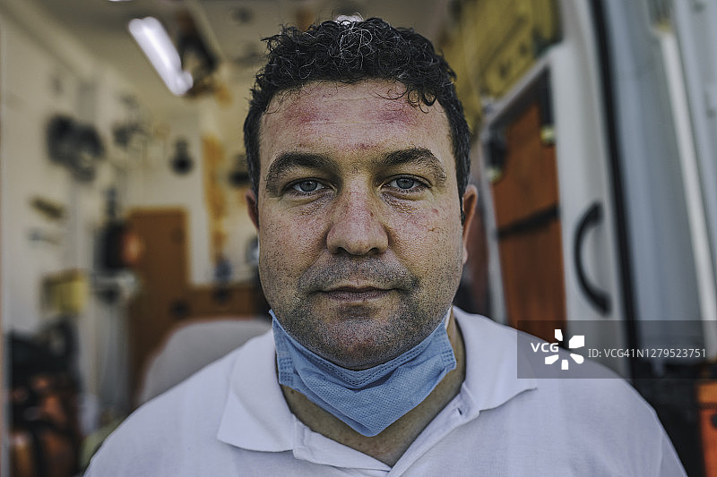 疲惫的男护理人员展示了因疫情期间整天戴口罩而造成的瘀伤图片素材