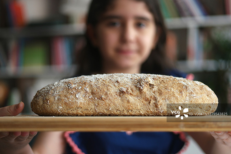 女孩手拿新鲜出炉的热面包图片素材