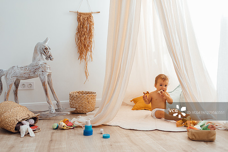 满是玩具的儿童游戏室：采用天然流苏装饰、环保天篷、柳条筐和木制玩具的精美托儿所，零浪费生态理念图片素材
