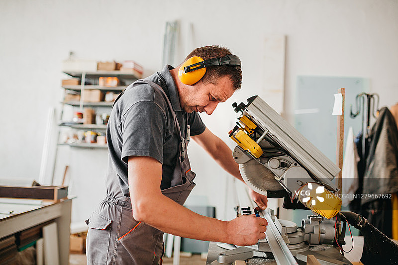 操作带锯切割机的工厂工人图片素材