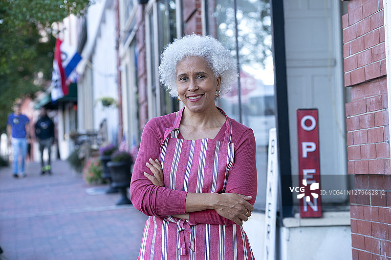 快乐的小店店主在店前图片素材