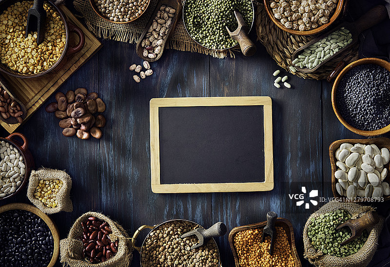 乡村木桌上各种干豆的低调图像俯视图，带空白黑板和复制空间图片素材