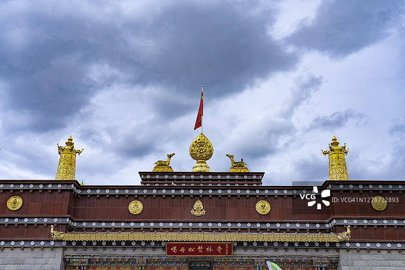 鸟儿飞过甘丹松赞林寺庙的天空图片素材