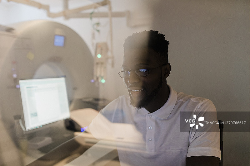 透过观察窗看到的MRI技术员图片素材
