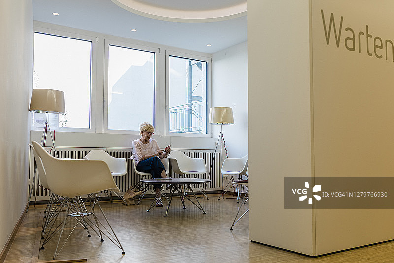 中年妇女坐在核磁共振诊所的候诊室里图片素材