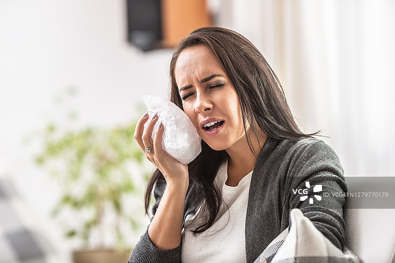 年轻女性冰敷脸颊时的牙痛图片素材