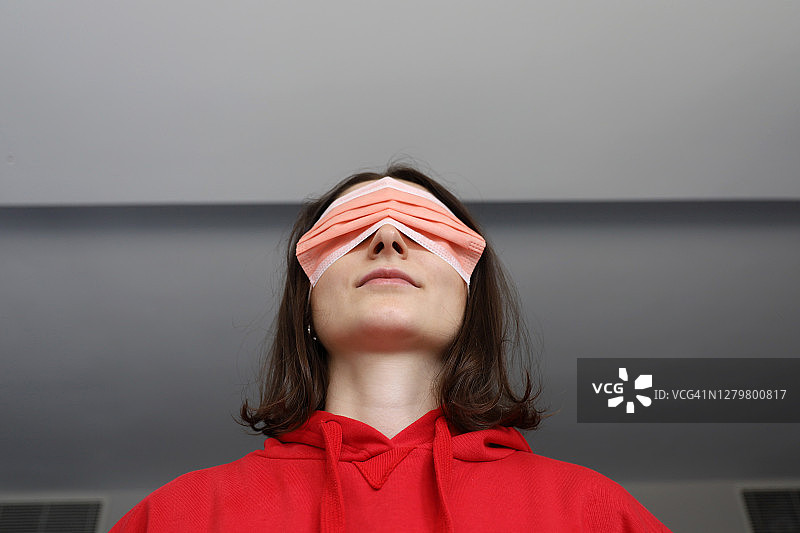 用外科口罩蒙住眼睛的女人图片素材