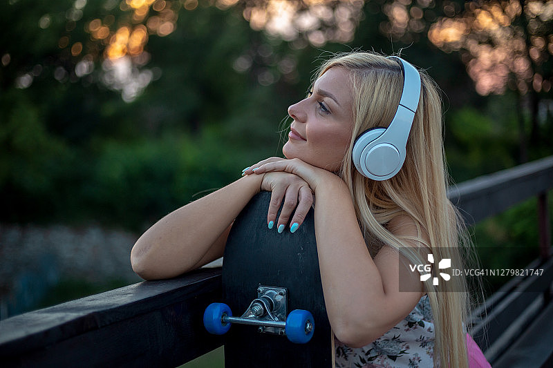 戴着耳机 holding smartphone的快乐女孩图片素材