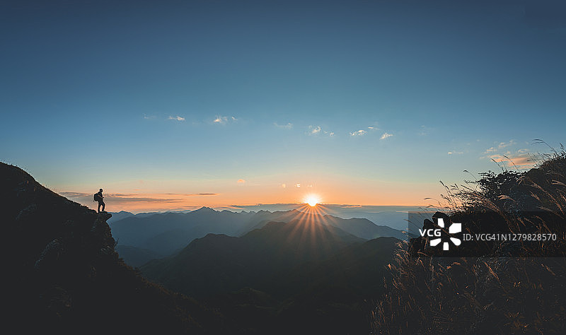 登山者站在悬崖边观看日落图片素材