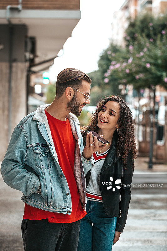 青少年情侣用手机与朋友交谈图片素材