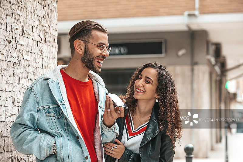 青少年情侣用手机与朋友交谈图片素材