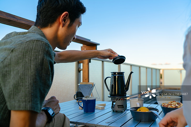 年轻男人在屋顶派对上准备咖啡图片素材